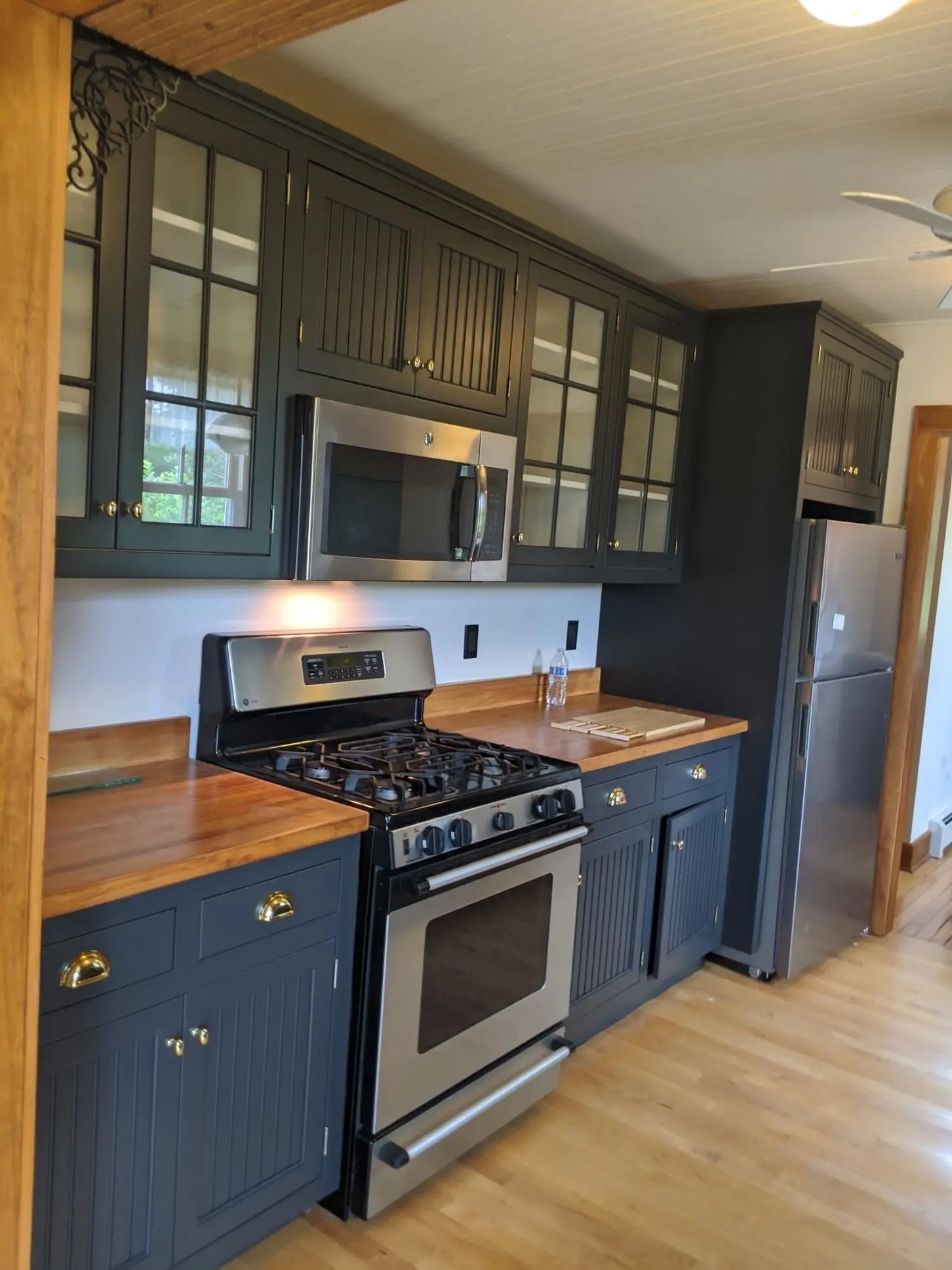 Modern kitchen with dark cabinets, stainless appliances, and wooden countertops
