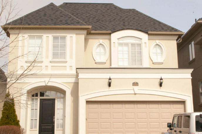 Beige luxury home exterior with arched windows and attached garage